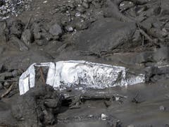 Das Wrack eines Fahrzeugs in den Schlammmassen. (Bild: Keystone/JEAN-CHRISTOPHE BOTT)
