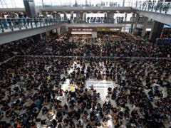 Tausende Demonstranten versammelten sich in der Abflug- und Ankunftshalle des internationalen Flughafens in Hongkong, um gegen die Regierung und die Polizeigewalt zu protestieren. (Bild: KEYSTONE/AP/VINCENT THIAN)