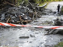 Der Fluss Losentze war am Sonntagabend bei Chamoson VS über die Ufer getreten und hatte ein Auto fortgeschwemmt. Ein 37-jähriger Genfer und ein sechsjähriges Mädchen werden seither vermisst. Die Sucharbeiten sind weiter im Gange. (Bild: Keystone/JEAN-CHRISTOPHE BOTT)