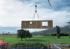 Die vorgefertigten Strohelemente werden mit dem Kran platziert. (Bild: PD)