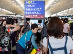 Anstehen am Check-In-Schalter: Am Hongkonger Flughafen wurde der Betrieb wieder aufgenommen. (Bild: KEYSTONE/EPA/MIGUEL CANDELA)