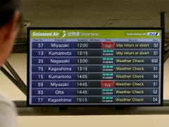 Ein Passagier studiert im Flughafen Haneda in Tokio die Informationen zu den Flügen. (Bild: KEYSTONE/EPA/KIMIMASA MAYAMA)