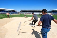 Das Sägemehl wird mit dem Bagger angeliefert und mit Rechen gleichmässig verteilt. (Bild: Stefan Kaiser, Zug, 14. August 2019)