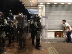 Ein Mann schliesst in Hongkong sein Geschäft, weil er Ausschreitungen und Sachbeschädigungen befürchtet. (Bild: KEYSTONE/EPA/JEROME FAVRE)