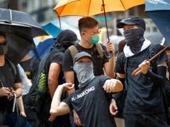 Ein Protestierender bereitet sich auf einen Eierwurf vor. Am Freitagabend und am Samstag sind in Hongkong wiederum Zehntausende auf die Strasse gegangen. (Bild: KEYSTONE/AP/VINCENT THIAN)