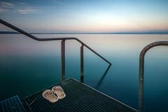 In der Abenddämmerung hat das Schwimmen im See einen besondern Reiz, aufgenommen an der Badeplattform des Schiffstegs in Altnau. (Bild: Wolfgang Reisser)