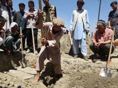 Ein Afghane hebt ein Grab für eine beim Anschlag getötete dreiköpfige Familie aus. (Bild: KEYSTONE/EPA/JAWAD JALALI)