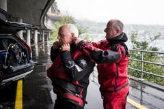 Der 73-jährige Ruedi Suter (links) taucht aus Sicherheitsgründen immer zu zweit. Sein Tauchpartner ist Stefan Ramp. Gegenseitig helfen sie sich auf beim Anziehen des Anzuges. (Bild: Manuela Jans-Koch, Hergiswil, 10. August 2019)
