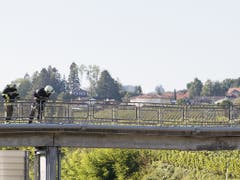 Feuerwehrleute inspizieren den Schaden an der Fussgängerbrücke. (Bild: KEYSTONE/CYRIL ZINGARO)