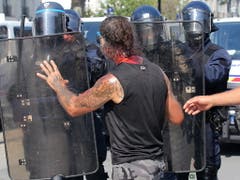 Unruhen nach dem Tod eines Mannes: Ein Demonstrant mit Blut am Hals konfrontiert Polizisten in Nantes. (Bild: KEYSTONE/EPA/THIBAULT VANDERMERSCH)