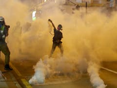 Ein Demonstrant in Hongkong wirft einen Tränengaskanister zurück. (Bild: KEYSTONE/AP/VINCENT THIAN)