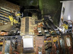 Erst nach mehreren Stunden hatten die Feuerwehrleute den Brand im Dachstock des Hauses in einem Genfer Wohnquartier unter Kontrolle. (Bild: KEYSTONE/SALVATORE DI NOLFI)