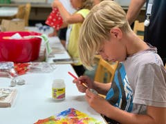 Luca vom Sommerlager Reiden hochkonzentriert beim «Schellen-Ursli»-Glöckchen verzieren. (Bild: Sommerlager Reiden, Zuoz, 1. August 2019)