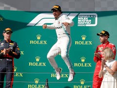 Ein Sieg wie eine Erlösung: Lewis Hamiltons Luftsprung bei der Siegerehrung, flankiert von Max Verstappen (links) und Sebastian Vettel (rechts). (Bild: KEYSTONE/AP/LASZLO BALOGH)