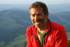 Der Bergretter vor seiner Hütte und der Aussicht ins Tal. (Foto: Martin Oswald)