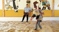 Daniel Schegg und Sämi Roth zeigen für die Zeitung ein paar Trainingsschwünge. Janosch Kobler macht den Ringrichter. Scannt man mit der App Xtend auf dem Handy obiges Bild, sieht man die drei in Bewegung. (Bild: Max Tinner)