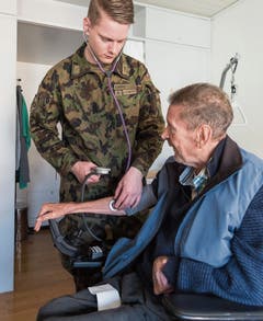 Soldat Eric Bayer misst den Blutdruck von Heimbewohner Christof Schiess.Bilder: Lisa Jenny
