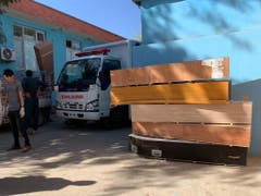 Spitalmitarbeiter in Kabul stapeln Särge, in welche die Opfer eines Selbstmordanschlags auf eine Wahlkampfveranstaltung gelegt werden sollen. (Bild: KEYSTONE/EPA/HEDAYATULLAH AMID)