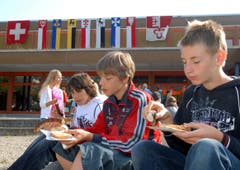 Die Schüler geniessen die Zämä-Zmittag-Bratwurst, von links Jan Lai, Sebastian Lieb und Arne Ming. (Bild: Markus von Rotz, Sarnen, 23. September 2009)