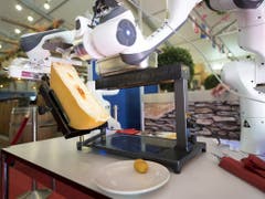 Eine Portion Raclette gefällig? Raclette-Abstreichroboter an einer Messe in Martigny VS. (Bild: KEYSTONE/LAURENT GILLIERON)