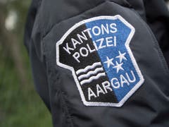 Das Logo der Kantonspolizei Aargau auf der Uniform eines Polizisten: Laut Polizei war ein 39-Jähriger betrunken in seinem neuen Tesla unterwegs, auf dem Schoss sein Kind. (Bild: KEYSTONE/URS FLUEELER)