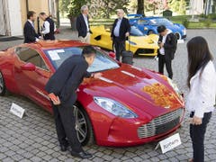 Ob das Kleingeld reicht für diesen roten Aston Martin One-77 Coupé aus dem Jahr 2011? Dahinter ein gelber LaFerrari-Ferrari und ein blauer Bugatti Veyron. (Bild: KEYSTONE/LAURENT GILLIERON)