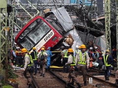 Rettungsarbeiten nach der Kollision eines Zugs mit einem Lastwagen auf einem Bahnübergang in der Nähe von Tokio. (Bild: KEYSTONE/EPA JIJI PRESS)