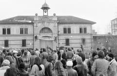 Sympathisanten des in Regensdorf einsitzenden Walter Stürm führen am 13. Dezember 1980 vor dem Tor der Strafanstalt eine Sympathiekundgebung durch und fordern die Freilassung, beziehungsweise die Aufhebung der Isolationshaft. Ein Transparent mit der Aufschrift: "Hochsicher ist totsicher» wird an der Gebäudefassade angebracht. (Bild: Keystone)