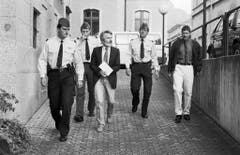 Walter Stürm wird am 30. Mai 1994 von Sicherheitskräften ins Gerichtgebäude von Sion zum Prozess geführt. (Bild: Keystone)